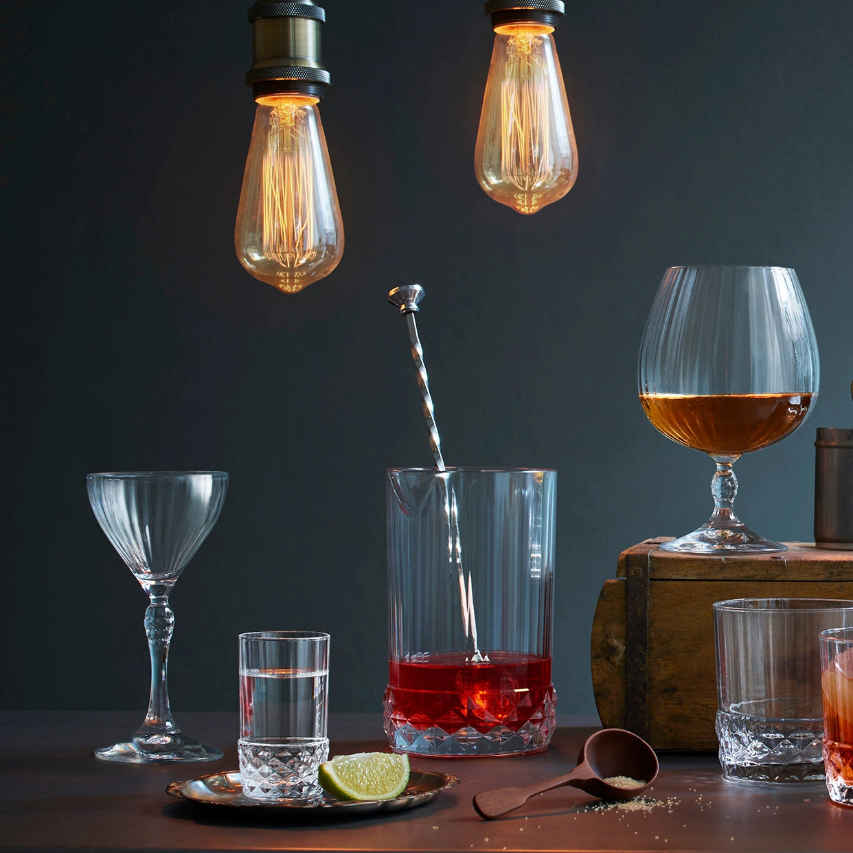 mixing glass america: il mixing glass con il bar spoon su un bancone in legno, fra i bicchieri della linea America 20s