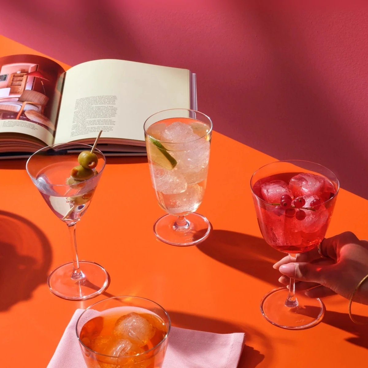 Calici della collezione Bargiani con i cocktail su un piano arancio